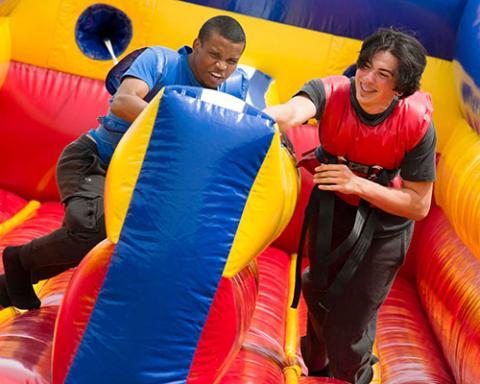 two students on a bouncy slide